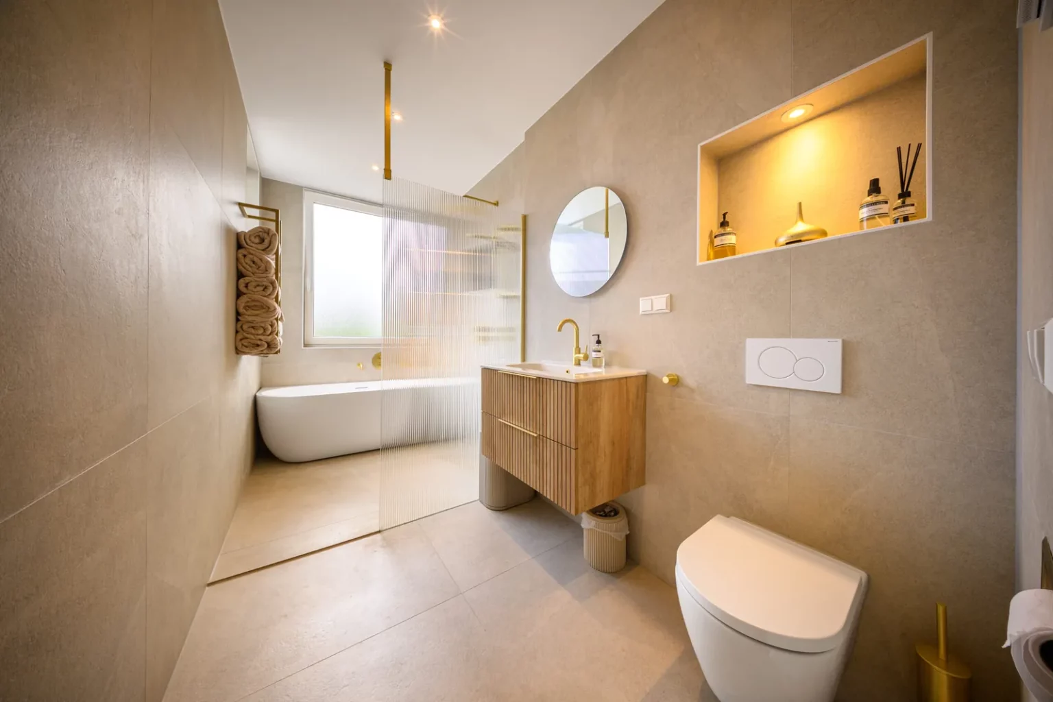 Badkamer met vrijstaand bad, houten meubel en ronde spiegel, Schiedam