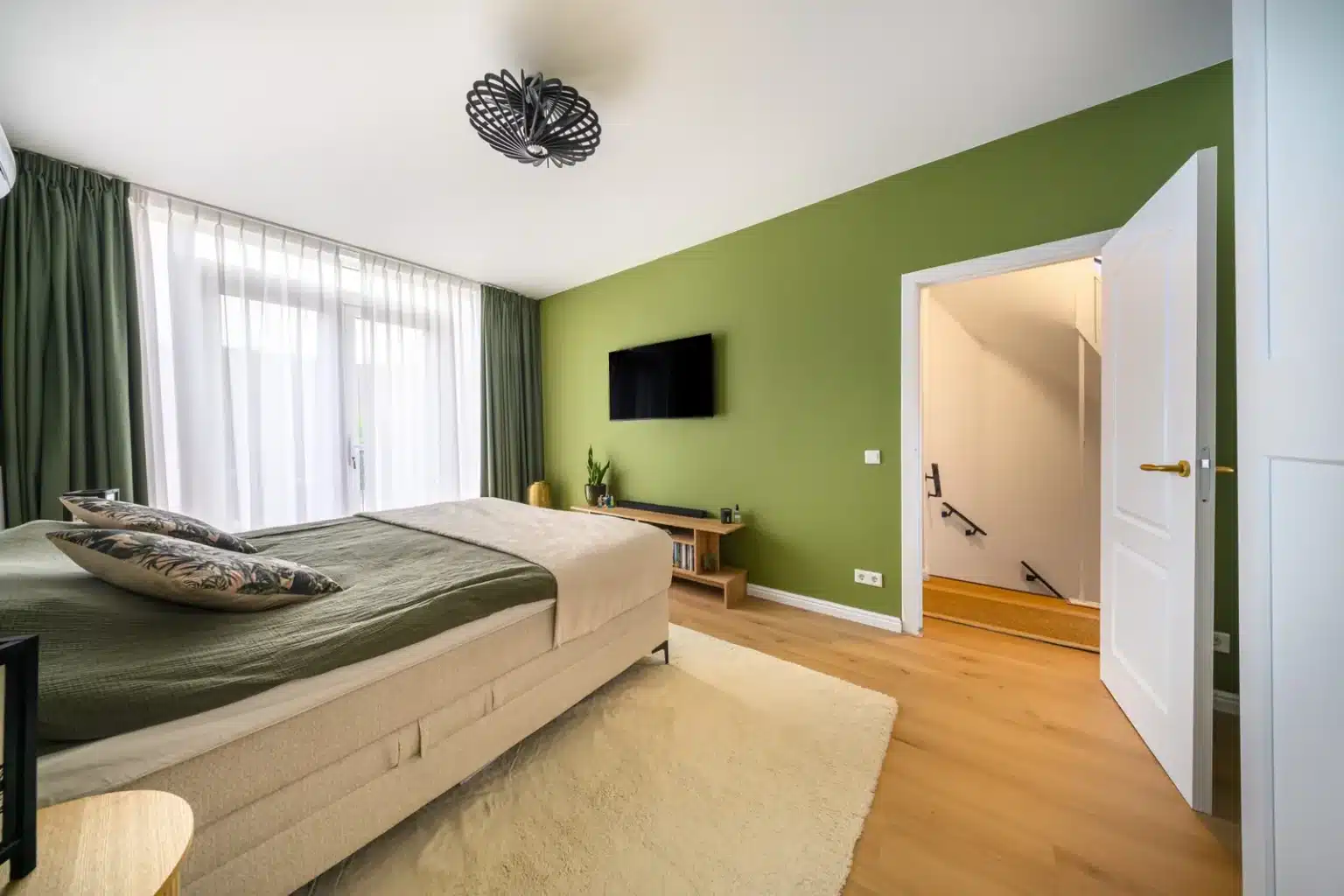 Slaapkamer met groene wand en bed na complete renovatie, Schiedam