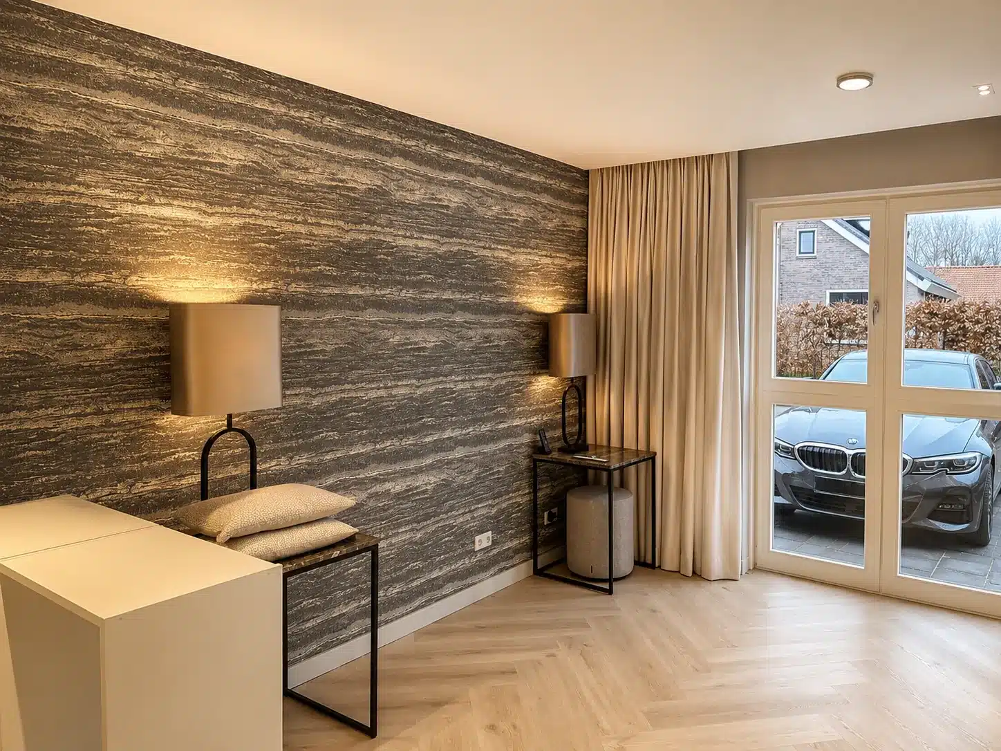 Woonkamer met natuursteenwand en tuindeuren na renovatie, Ouddorp