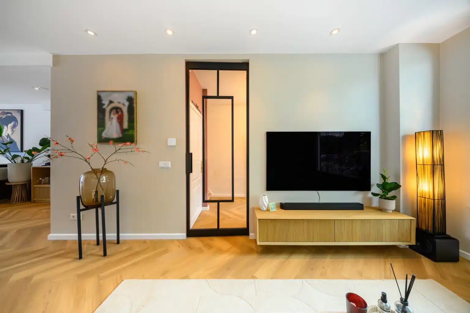 Woonkamer met televisiemeubel en visgraatvloer na renovatie, Schiedam