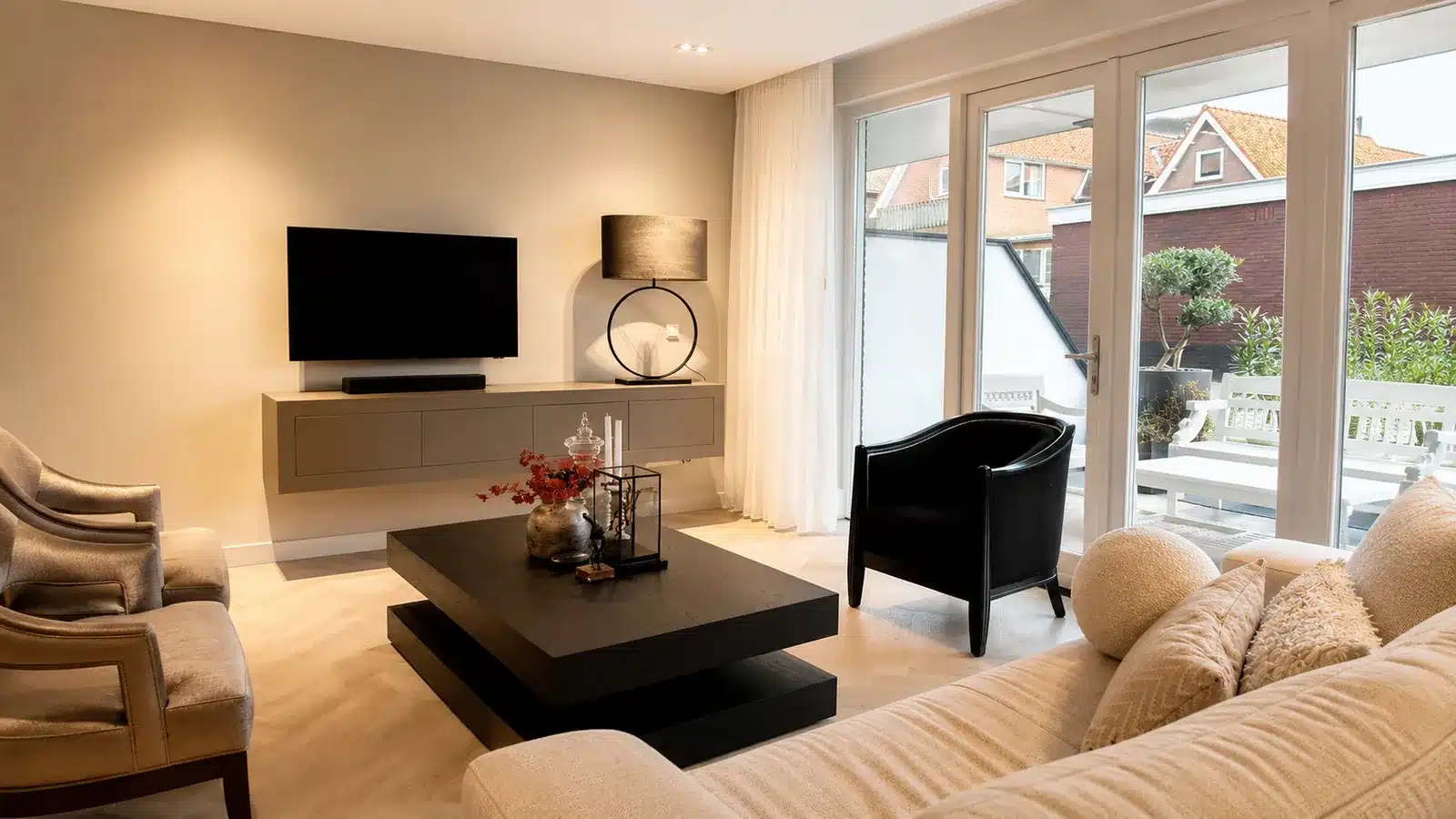 Woonkamer met bank, televisie en tuindeuren na renovatie, Ouddorp