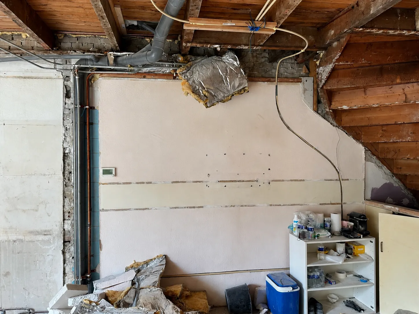 Woonkamer voor renovatie, leidingwerk en kaal metselwerk zichtbaar, Schiedam