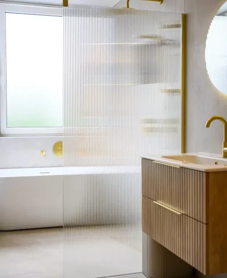 Badkamer met ligbad en goudkleurige kraan na renovatie, Schiedam