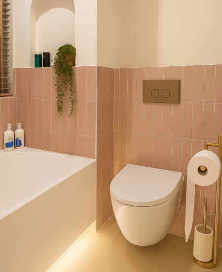 Badkamer met roze tegels, ligbad en toilet na renovatie, Den Haag