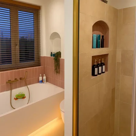 Badkamer met nis en verzorgingsproducten na renovatie, Den Haag