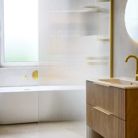 Badkamer met houten wastafelmeubel en verlichte spiegel, Schiedam