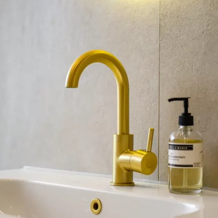 Detail van goudkleurige wastafelkraan na renovatie, Schiedam