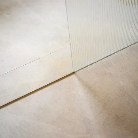 Detail van strak tegelwerk in de badkamer na renovatie, Schiedam