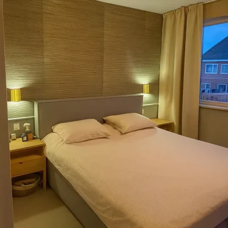Slaapkamer met bed en houten wandpaneel, Berkel en Rodenrijs