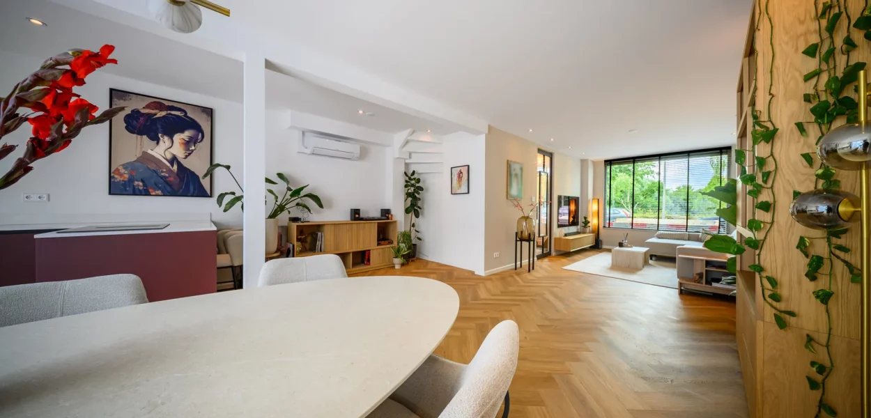 Woonkamer met visgraatvloer en eethoek na complete renovatie,